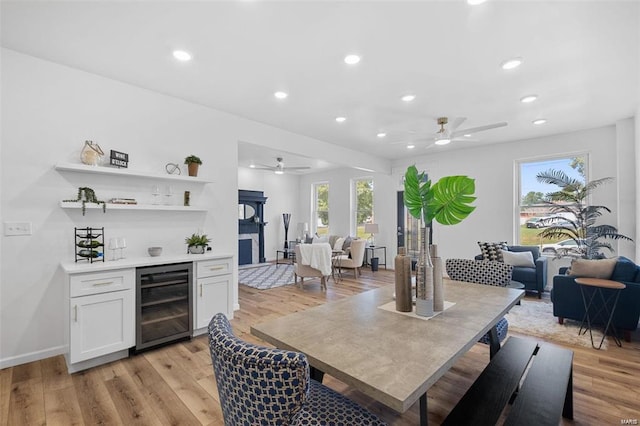 dining area with beverage cooler, recessed lighting, a wealth of natural light, and light wood-style floors