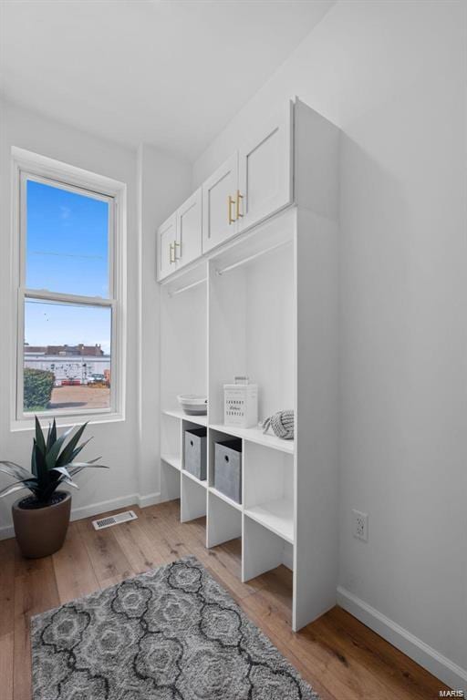 mudroom featuring visible vents, baseboards, and light wood finished floors