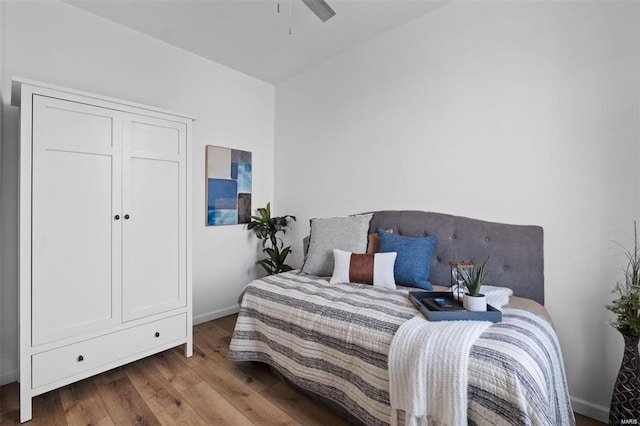 bedroom with ceiling fan, baseboards, and wood finished floors