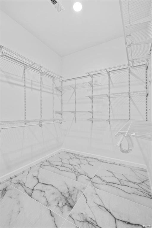 spacious closet featuring visible vents and marble finish floor