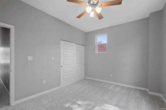 unfurnished bedroom with a closet, carpet flooring, a ceiling fan, and baseboards