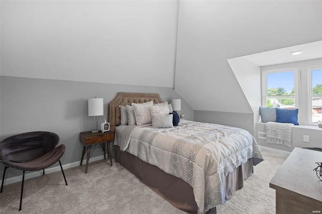 carpeted bedroom featuring baseboards and vaulted ceiling