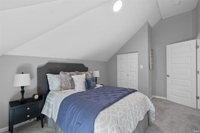 bedroom with a closet, lofted ceiling, carpet, and baseboards