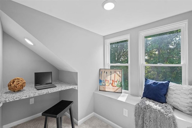 office area featuring baseboards, lofted ceiling, carpet flooring, and built in study area