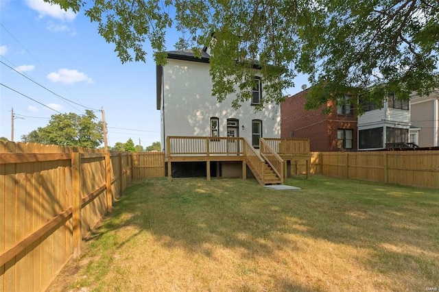 back of house featuring a wooden deck, stairs, a lawn, stucco siding, and a fenced backyard