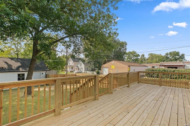 wooden deck featuring a residential view, an outbuilding, and a lawn