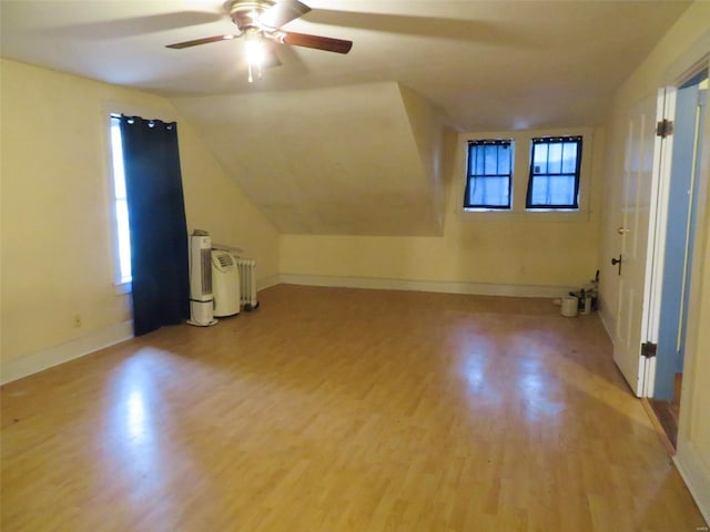 additional living space featuring lofted ceiling, ceiling fan, and light wood-type flooring