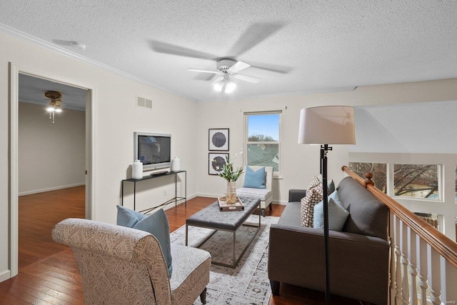 living room featuring wood-type flooring, a textured ceiling, ceiling fan, and crown molding