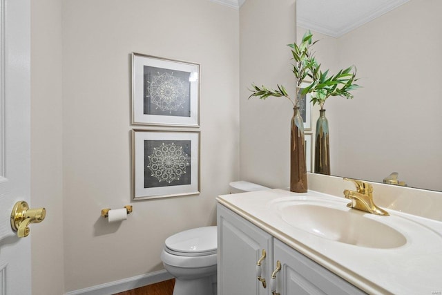 bathroom featuring vanity, ornamental molding, and toilet