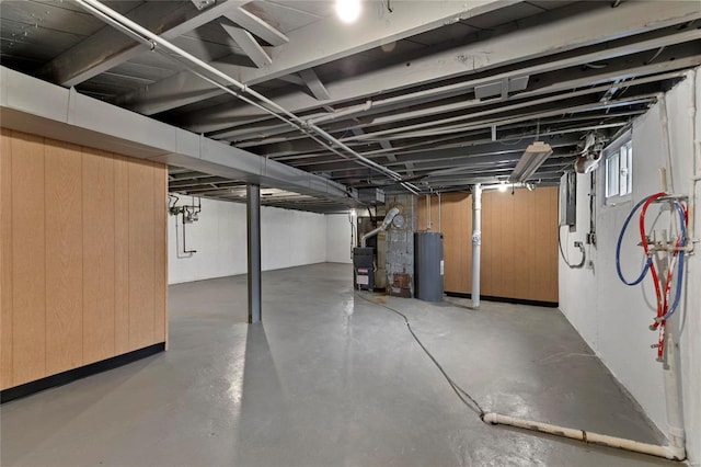 basement featuring wooden walls and water heater