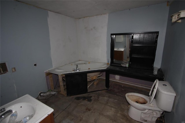 bathroom with a tub, vanity, and toilet