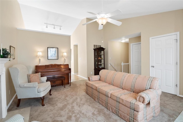 carpeted living room with ceiling fan, vaulted ceiling, and track lighting