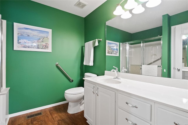 bathroom with toilet, a shower with door, hardwood / wood-style flooring, and vanity