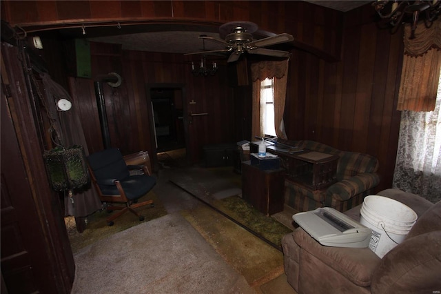 living room featuring wood walls and ceiling fan