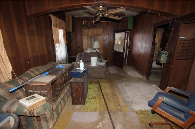 interior space featuring ceiling fan and wood walls