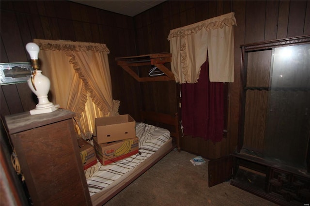 bedroom with carpet flooring and wood walls