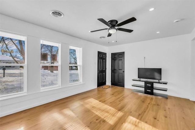 unfurnished living room featuring ceiling fan and wood-type flooring