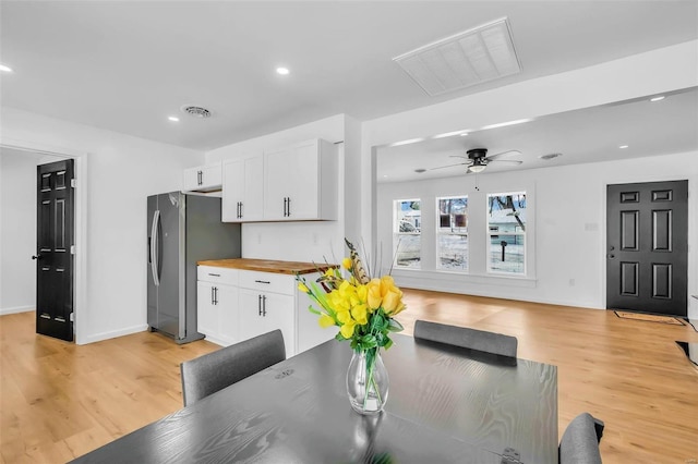 dining area with light hardwood / wood-style floors and ceiling fan