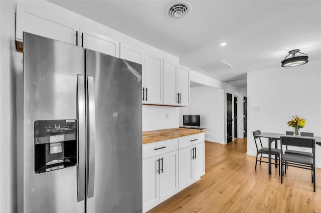 kitchen featuring butcher block countertops, white cabinets, stainless steel refrigerator with ice dispenser, and light hardwood / wood-style flooring