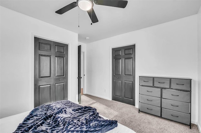 bedroom with ceiling fan, light colored carpet, and a closet