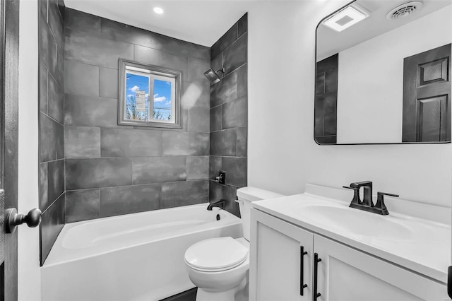 full bathroom featuring vanity, tiled shower / bath combo, and toilet