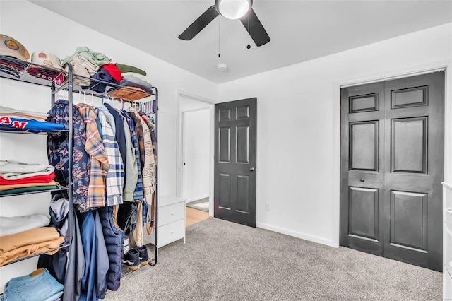 walk in closet with carpet and ceiling fan