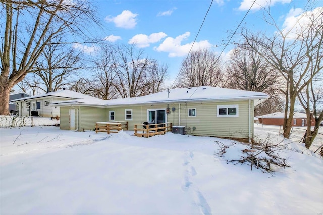 snow covered house featuring a deck and central AC unit