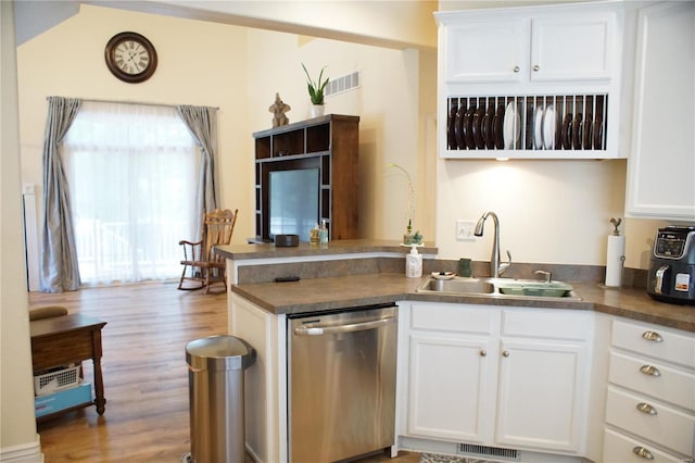 kitchen with kitchen peninsula, white cabinetry, dishwasher, and sink