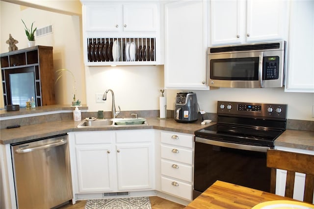 kitchen featuring white cabinetry, sink, and appliances with stainless steel finishes