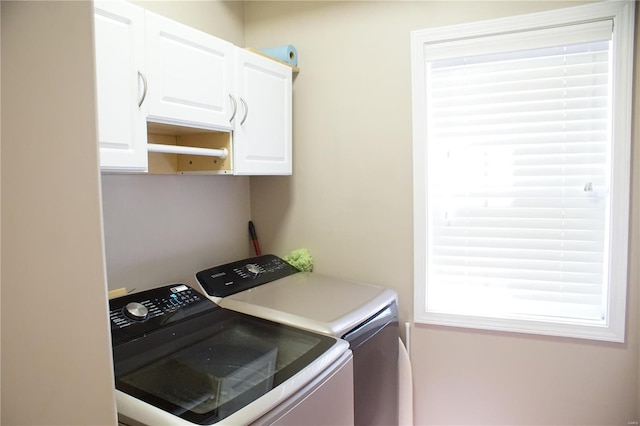 washroom featuring washer and clothes dryer and cabinets