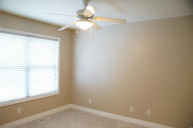 carpeted spare room featuring ceiling fan