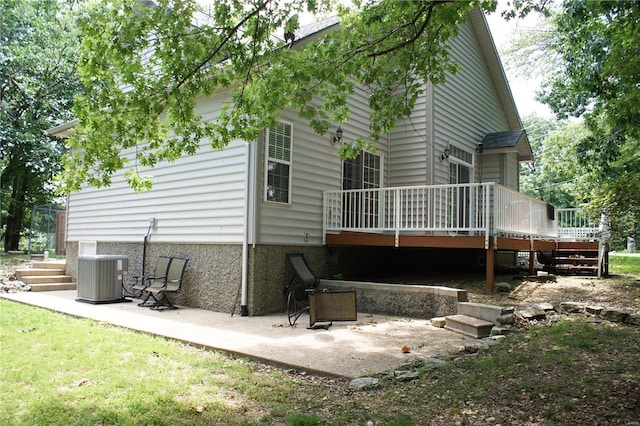 back of house featuring central AC, a wooden deck, and a patio