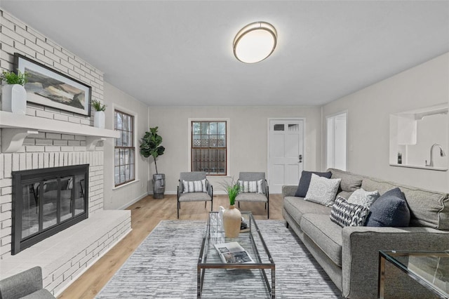 living room with light wood-type flooring and a fireplace