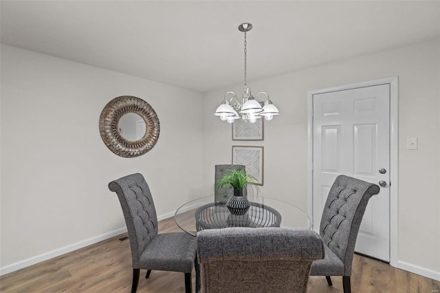 dining space with an inviting chandelier and dark wood-type flooring