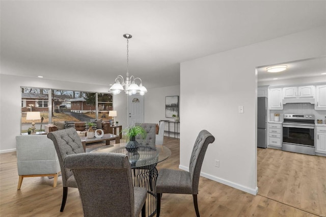 dining room with a chandelier and light hardwood / wood-style floors