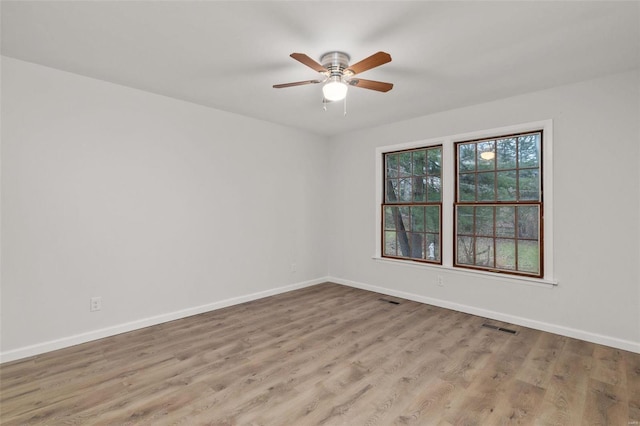 empty room with ceiling fan and light hardwood / wood-style floors