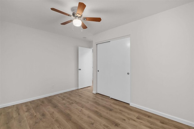 unfurnished bedroom featuring wood-type flooring, ceiling fan, and a closet