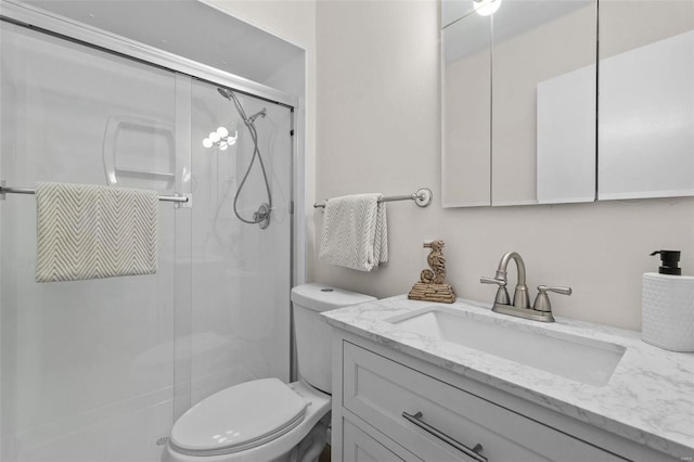 bathroom featuring vanity, toilet, and walk in shower