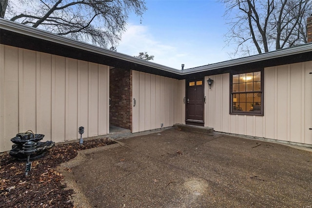 view of exterior entry with a patio