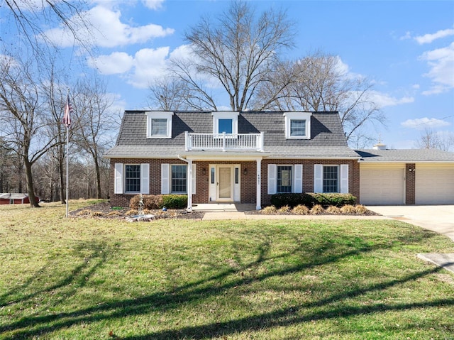 view of front facade featuring a balcony, driveway, a front yard, and brick siding