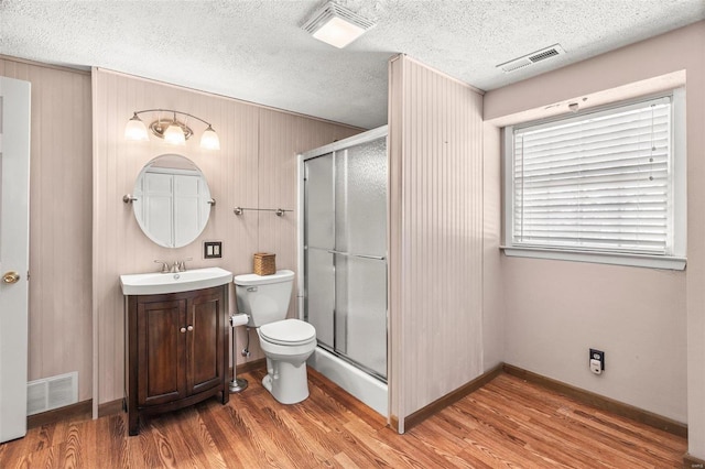 bathroom with a stall shower, visible vents, and wood finished floors