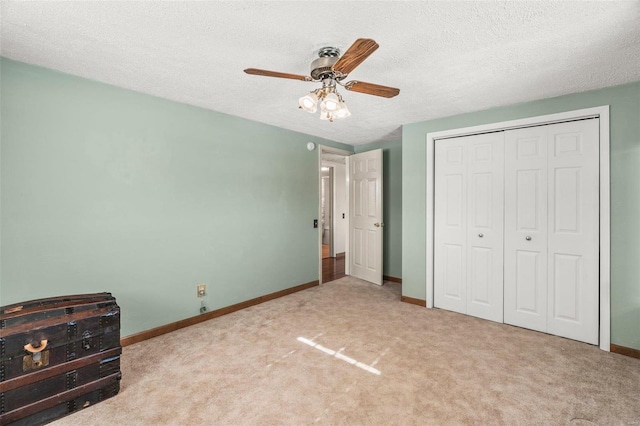 unfurnished bedroom featuring carpet, a closet, a textured ceiling, and baseboards