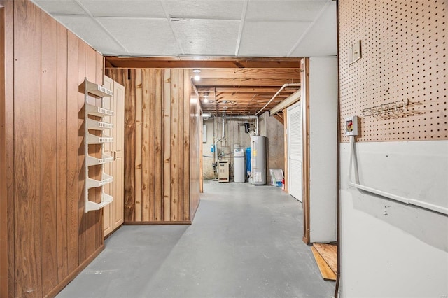 unfinished basement with wooden walls and water heater