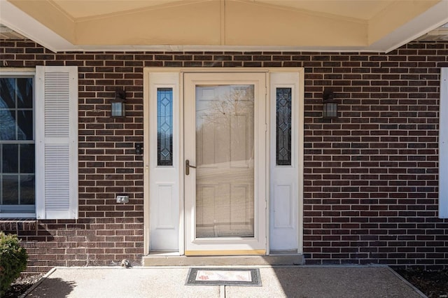 view of exterior entry featuring brick siding