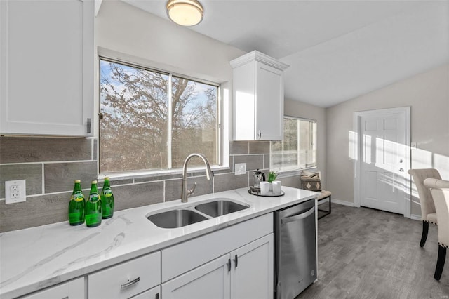 kitchen with a sink, white cabinets, vaulted ceiling, decorative backsplash, and dishwasher