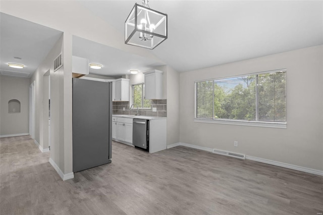 kitchen with visible vents, backsplash, stainless steel appliances, light countertops, and a sink