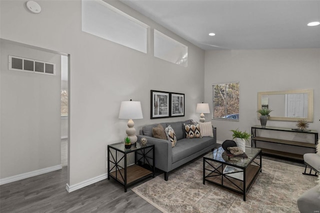 living room featuring lofted ceiling, recessed lighting, wood finished floors, visible vents, and baseboards