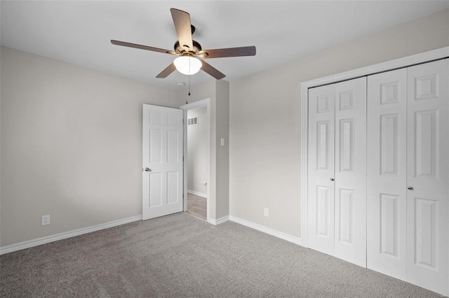 unfurnished bedroom with visible vents, baseboards, a ceiling fan, carpet, and a closet