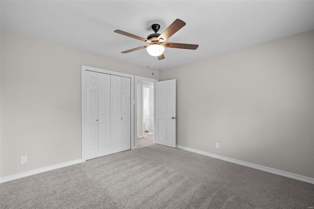 unfurnished bedroom with carpet floors, a ceiling fan, baseboards, and a closet