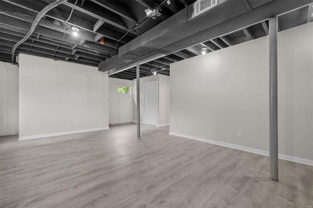 below grade area featuring baseboards and wood finished floors